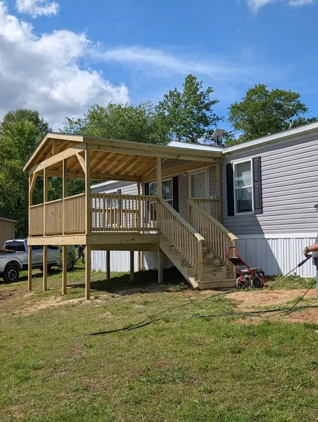 New covered wood porch with railings and stairs built on a manufactured home